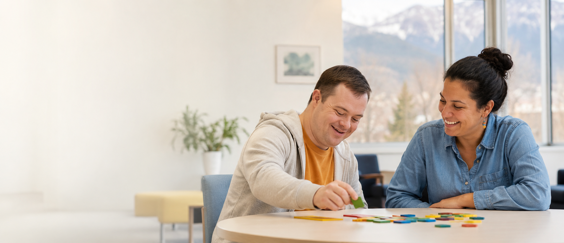 A man and his support professional smiling over a colorful tile activity